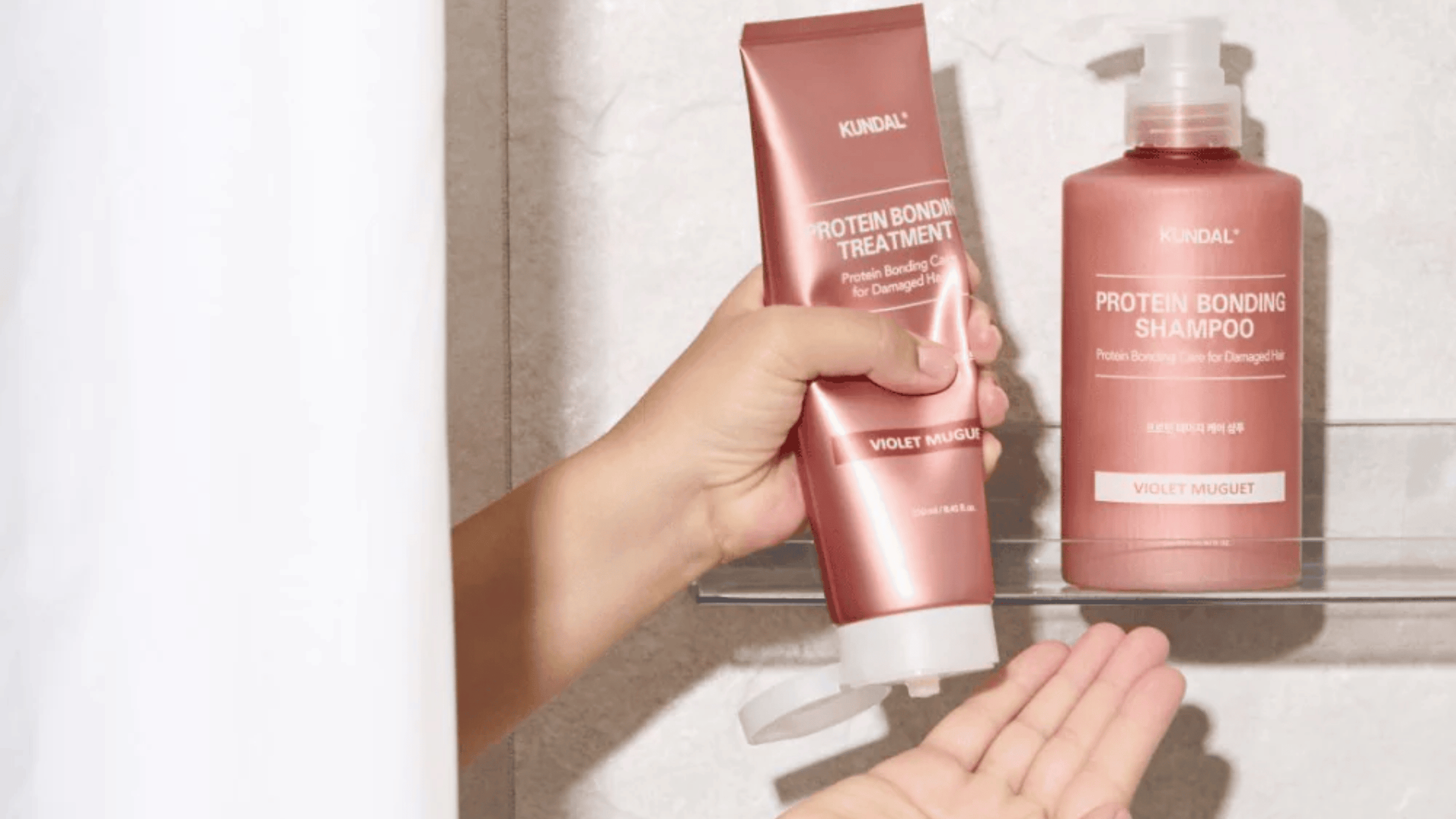 Kundal Protein Bonding Shampoo och Treatment i färgen Violet Muguet på duschylla. Proteinberikad hårvård för skadat hår som stärker och återfuktar på djupet.