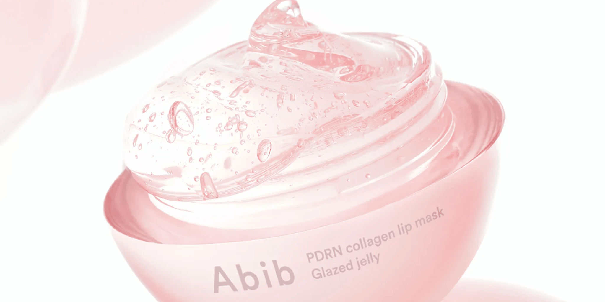 Närbild av en öppen burk med Abib PDRN Collagen Lip Mask i rosa "glazed jelly"-konsistens.