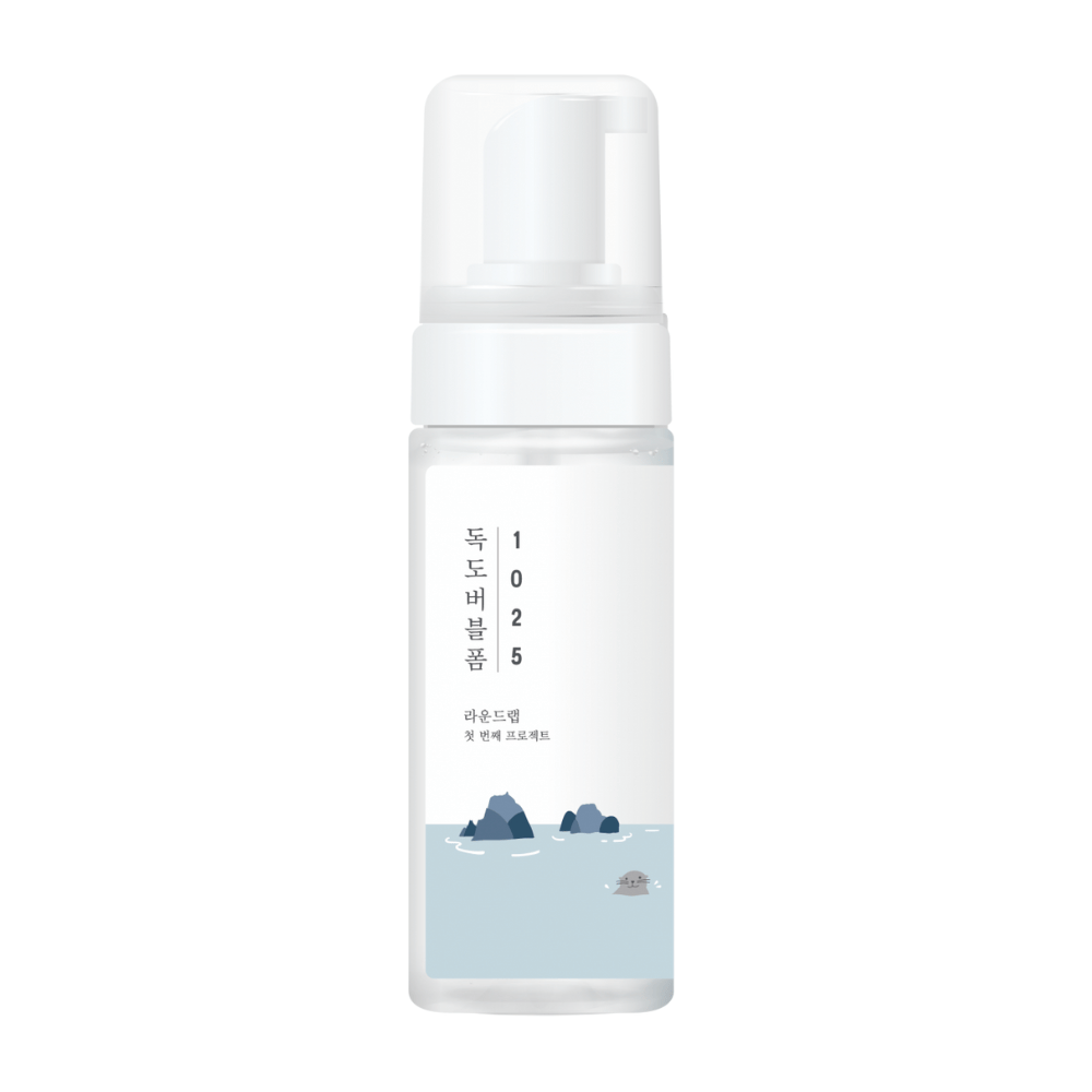 1025 Dokdo Bubble Foam" je čistiaci produkt na tvár od ROUND LAB, zabalený v bielej pumpovacej fľaši s jednoduchým a čistým dizajnom, ozdobený textom a minimalistickými ilustráciami morských scenérií. 