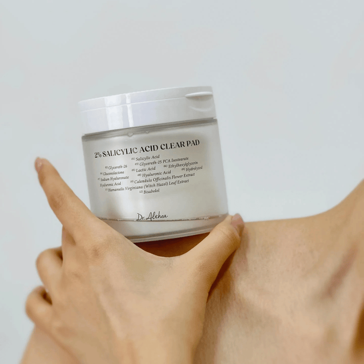 Dr. Althea 2% Salicylic Acid Clear Pad držané v ruke. Tonerové vankúšiky s 2% kyselinou salicylovou, ktoré jemne exfoliujú, upokojujú pokožku a zlepšujú štruktúru pokožky.