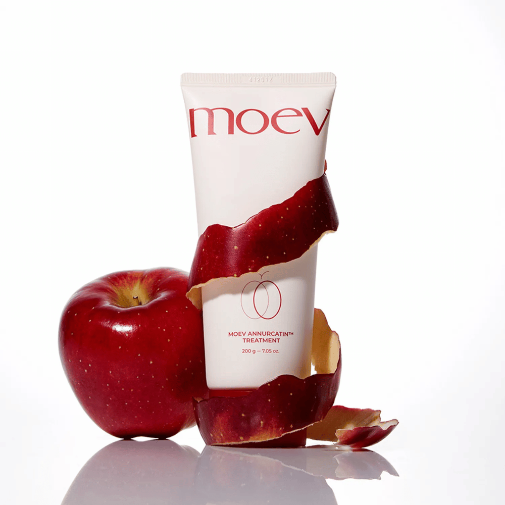 MOEV Annurcatin Treatment spolu s červenými jablkami – symbolizuje prirodzenú silu Annurca-jablka, ktorá ošetruje a chráni vlasy do hĺbky.