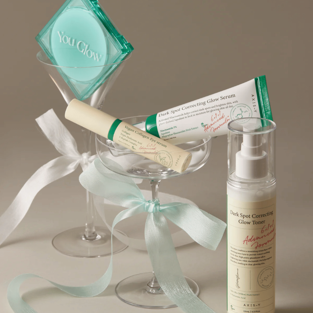 Obrázok súpravy starostlivosti o pleť od AXIS-Y s očným sérom, sérom a tonerom – elegantne umiestnené v koktailovom pohári so saténovou stuhou, ideálne pre luxusnú darčekovú prezentáciu.