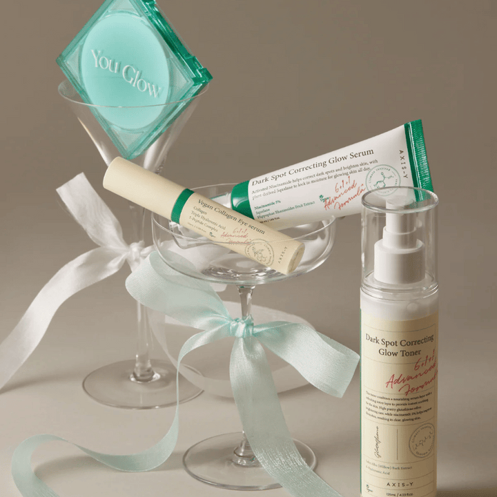 Obrázok súpravy starostlivosti o pleť od AXIS-Y s očným sérom, sérom a tonerom – elegantne umiestnené v koktailovom pohári so saténovou stuhou, ideálne pre luxusnú darčekovú prezentáciu.