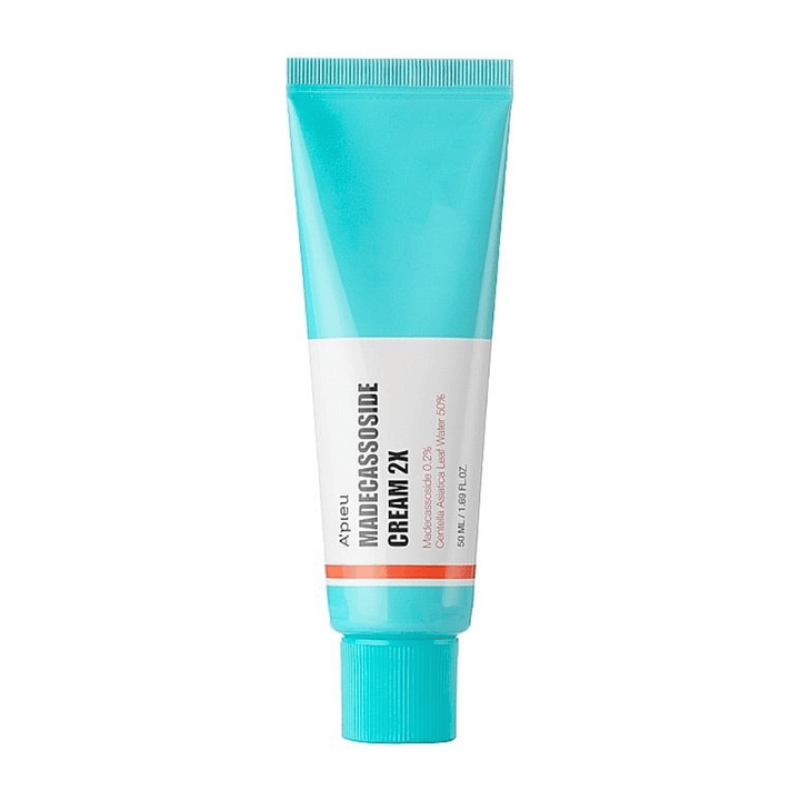 Tuba s krémom A'PIEU Madecassoside Cream 2X, s vrchom v svetlej tyrkysovej farbe, ktorá prechádza do bielej smerom k spodku. Tuba má jasný text, ktorý uvádza značku a názov produktu, ako aj aktívnu zložku Madecassoside 2%. Oranžový akcentový pruh obkolesuje tubu. Produkt sa zdá byť krémom určeným na starostlivosť o pleť a jej obnovu. Pozadie je neutrálne, aby sa udržala pozornosť na produkte.