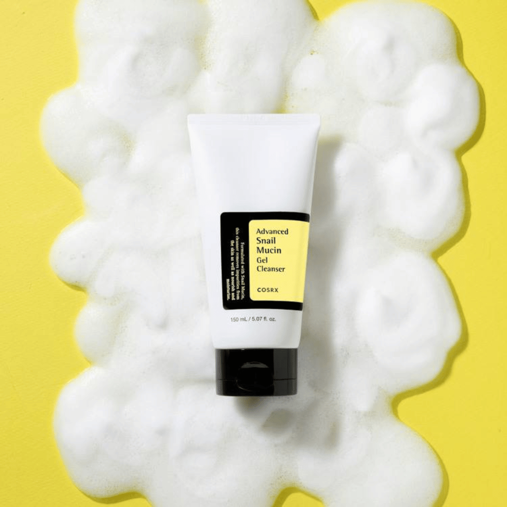 COSRX Advanced Snail Mucin Gel Cleanser 150 ml obklopený bohatou penou na žltom pozadí – jemné kórejské čistenie tváre s snail mucin na hydratáciu a žiarivosť.