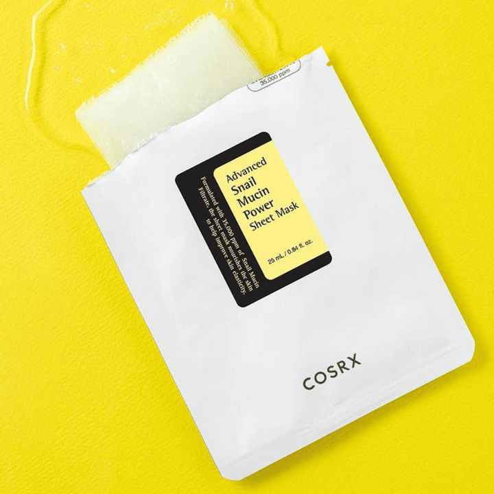 COSRX Advanced Snail Mucin Power Sheet Mask na žltom pozadí, hydratačná a opravná pleťová maska so slimačím sekrétom pre zvýšenú elasticitu a žiarivosť.