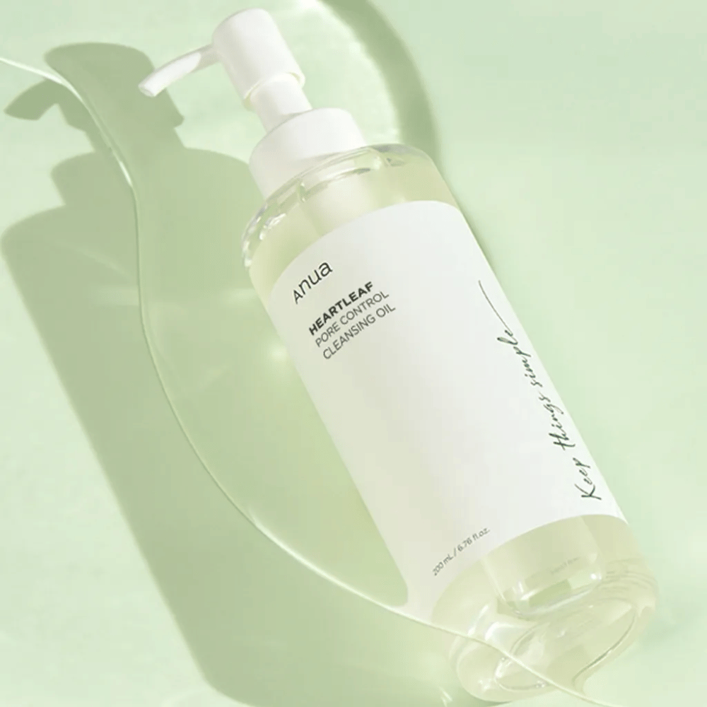 Na obrázku je ANUA Heartleaf Pore Control Cleansing Oil, čistiaci olej s pumpičkovým dizajnom. Fľaša je priehľadná a obsah vyzerá ako ľahká, olejová konzistencia. Etiketa nesie logo značky a názov produktu v jednoduchej a elegantnej texte, čo prispieva k pocitu minimalistickej krásy a čistoty. Súčasťou dizajnu je nápis "Keep things simple", čo naznačuje filozofiu jednoduchosti v starostlivosti o pleť. Fľaša obsahuje 200 ml produktu.