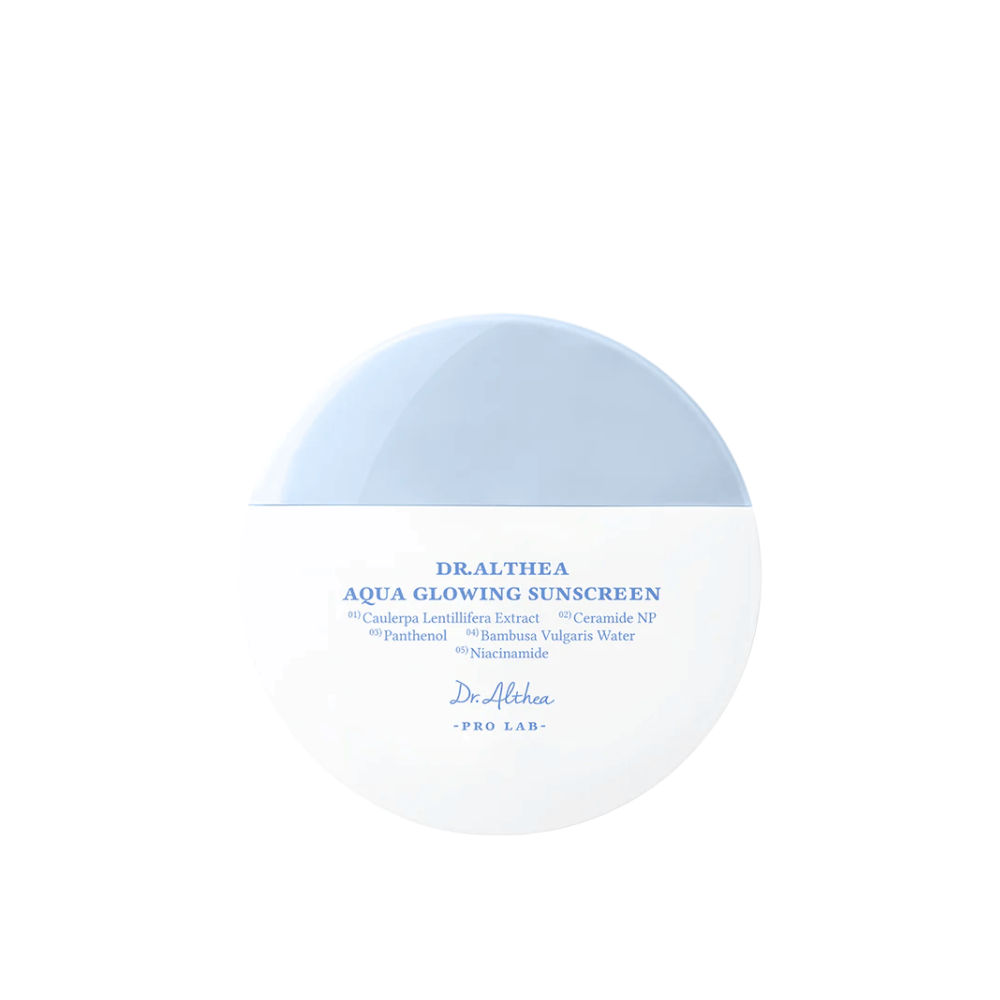 Obrázok produktu Dr. Althea Aqua Glowing Sunscreen – okrúhly opaľovací krém v bielom a svetlomodrom obale s modrým textom, ktorý zvýrazňuje hydratačné zložky ako niacínamid a ceramidy.