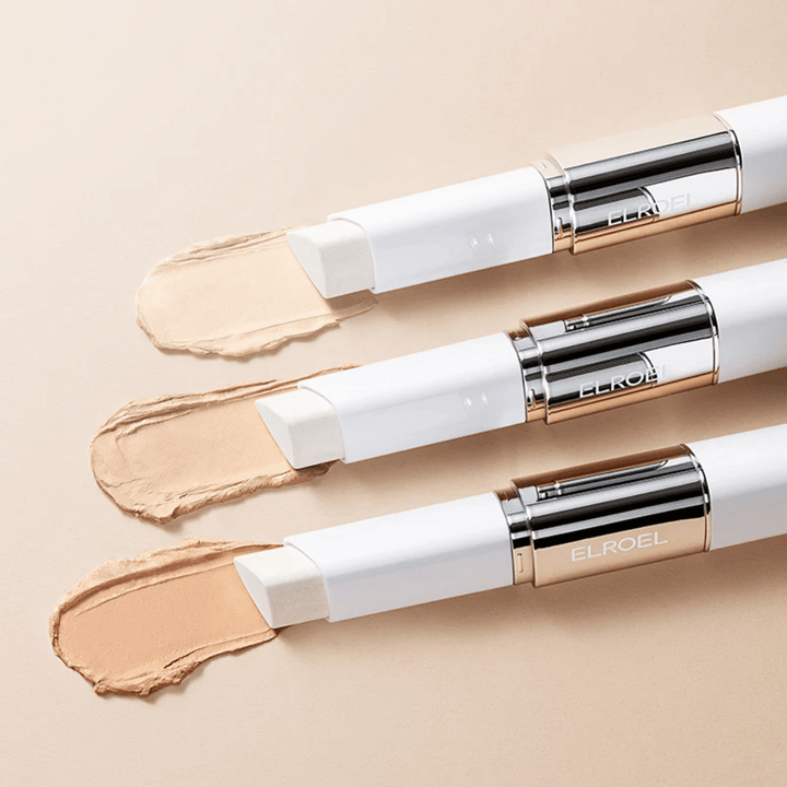 ELROEL Blanc Cover Cream Stick concealer s vstavaným štetcom, viac tyčiniek zoradených, aby sa ukázal dizajn produktu a aplikácia.