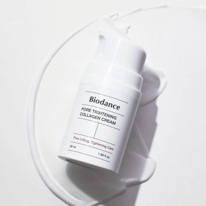 Biodance Pore Tightening Collagen Cream v bielej pumpovacej fľaši, ležiacej na víre bieleho krému.
