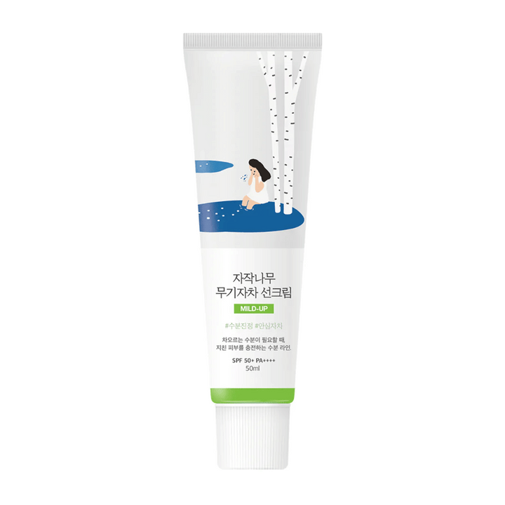 Birch Juice Moisturizing Mild Up Sunscreen SPF 50+ PA++++ – opaľovací krém v bielej tube s ilustráciou brezy a dievčiny pri vodnom toku, 50 ml.