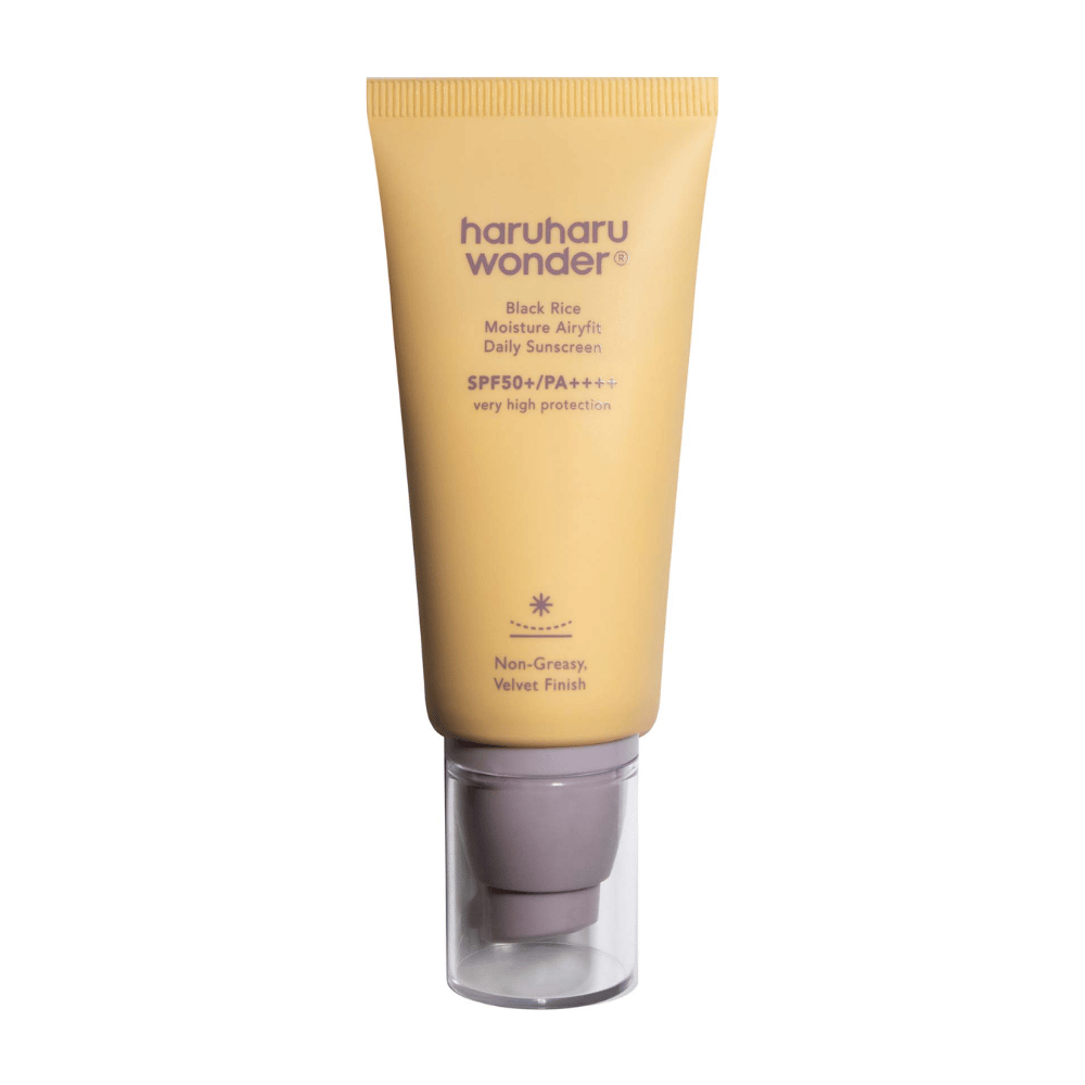 Žltá tuba s Haruharu Wonder Black Rice Moisture Airyfit Daily Sunscreen SPF 50+ PA++++. Tuba má priehľadný uzáver a text, ktorý popisuje vysokú úroveň ochrany opaľovacieho krému a jeho neolejovitý, zamatový povrch.