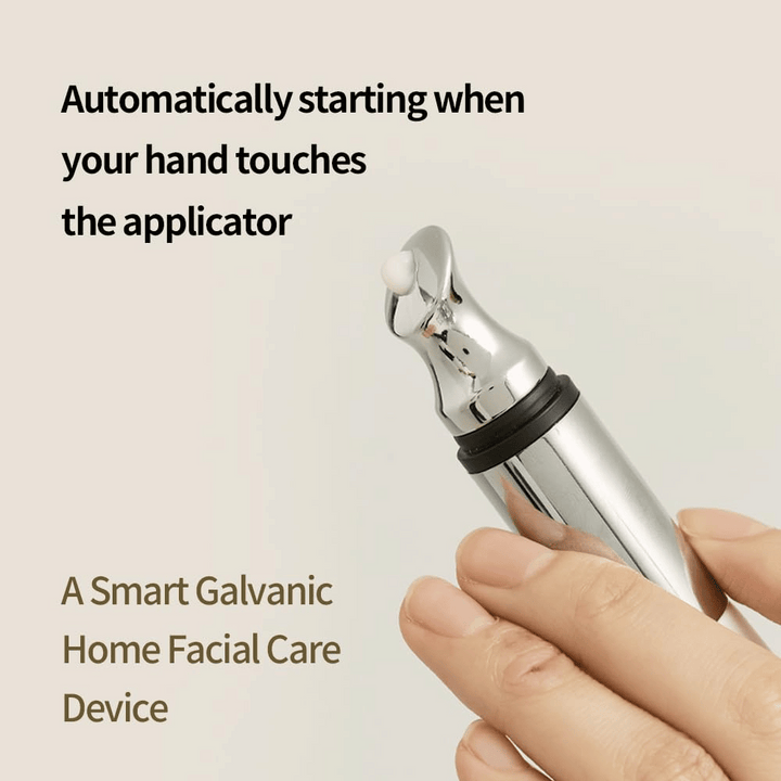 Detailný záber na ruku držiacu galvanický aplikátor na očný krém s automatickou funkciou spustenia pri dotyku. Text na obrázku opisuje funkciu a zariadenie ako inteligentný domáci nástroj na starostlivosť o tvár.