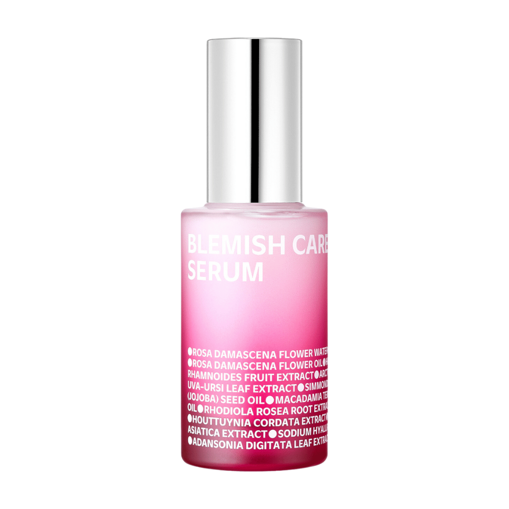 Osamelá fľaša Blemish Care Serum s prechodovým ružovým dizajnom a strieborným uzáverom, stojaca proti bielej pozadiu. Text na fľaši uvádza zložky ako ružová voda, oleje a extrakty, vytlačené bielou farbou na prednej strane.