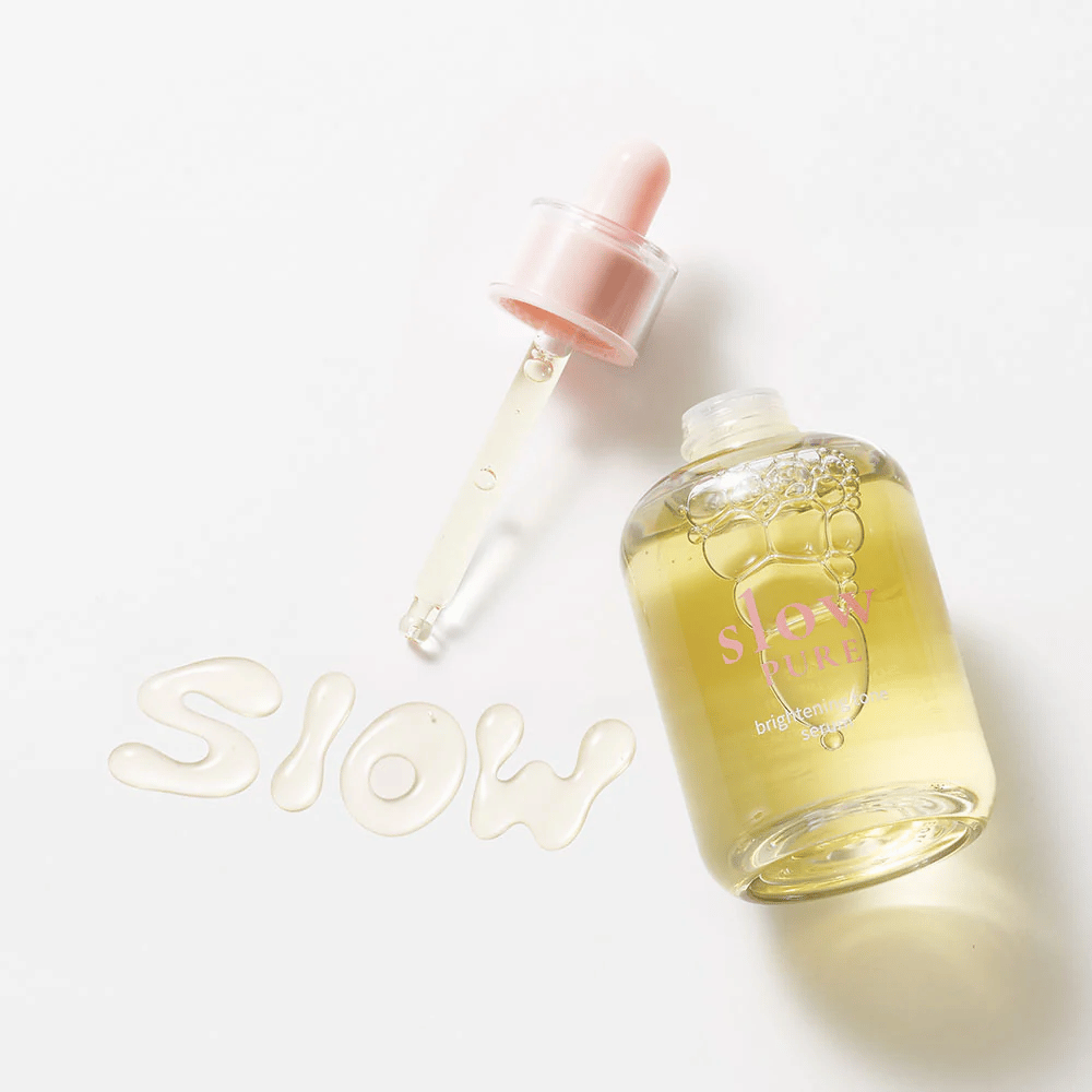 Slow Pure Brightening Tone Serum s otvorenou pipetou, text napísaný v sére na povrchu: "Slow".