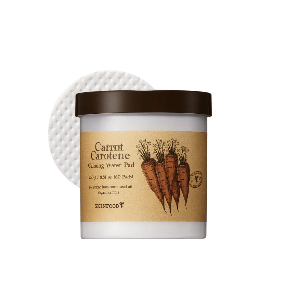 Pohár "Carrot Carotene Calming Water Pad" od SKINFOOD. Pohár obsahuje 60 podložiek a je označený obrázkom mrkvy. Produkt, ktorý je založený na mrkvovom oleji, je vhodný pre vegánov a je navrhnutý na upokojenie pokožky.