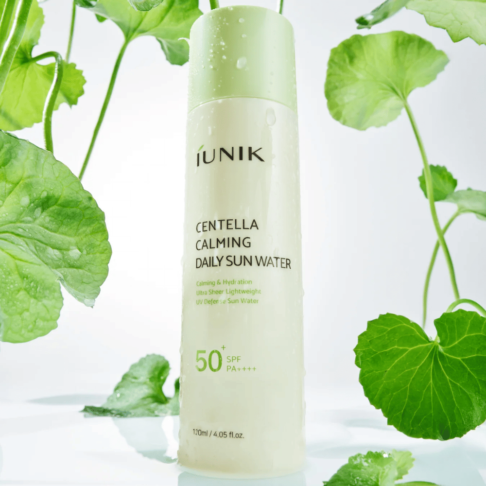 2. iUNIK Centella Calming Daily Sun Water SPF50+ PA++++ – hydratačná slnečná ochrana s centella asiatica obklopená zelenými listami a kvapkami vody