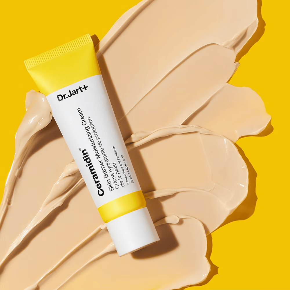 Tuba s Dr. Jart+ Ceramidin Skin Barrier Moisturizing Cream na žltom pozadí s rozotretým krémom.