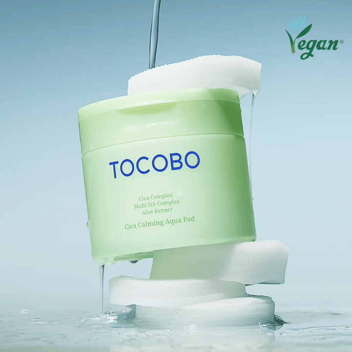 TOCOBO Cica Calming Aqua Pad umiestnený medzi toner pads s tečúcim essence. Symbol vegan zdôrazňuje vegánske zloženie produktu a jeho profil šetrný k pokožke.