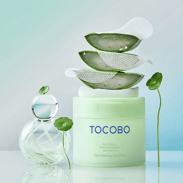 TOCOBO Cica Calming Aqua Pad je zobrazený spolu s toner pads, aloe vera a centellou asiatickou. Obrázok vyzdvihuje hydratačné a upokojujúce zložky produktu.