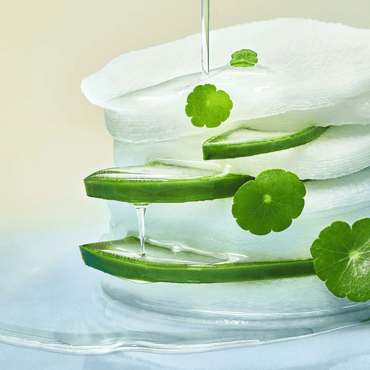 Detailný záber na plátky aloe vera, hydratačný toner pads a listy centelly asiatickej. Gél kvapká medzi ingredienciami, aby ilustroval upokojujúce, chladivé a hydratačné vlastnosti.
