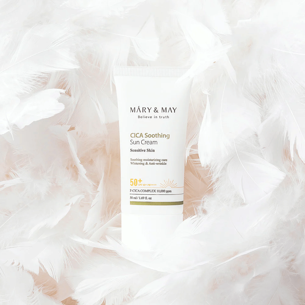 Mary&May CICA Soothing Sun Cream obklopený jemným bielym perím. Obrázok vyjadruje pocit šetrnosti, komfortu a ľahkého zloženia prispôsobeného pre citlivú pokožku.