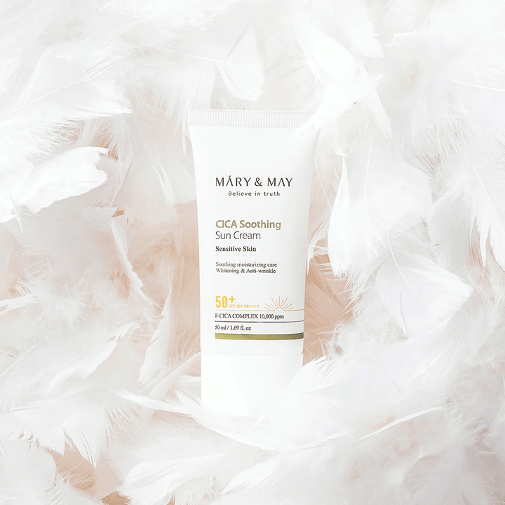Mary&May CICA Soothing Sun Cream obklopený jemným bielym perím. Obrázok vyjadruje pocit šetrnosti, komfortu a ľahkého zloženia prispôsobeného pre citlivú pokožku.