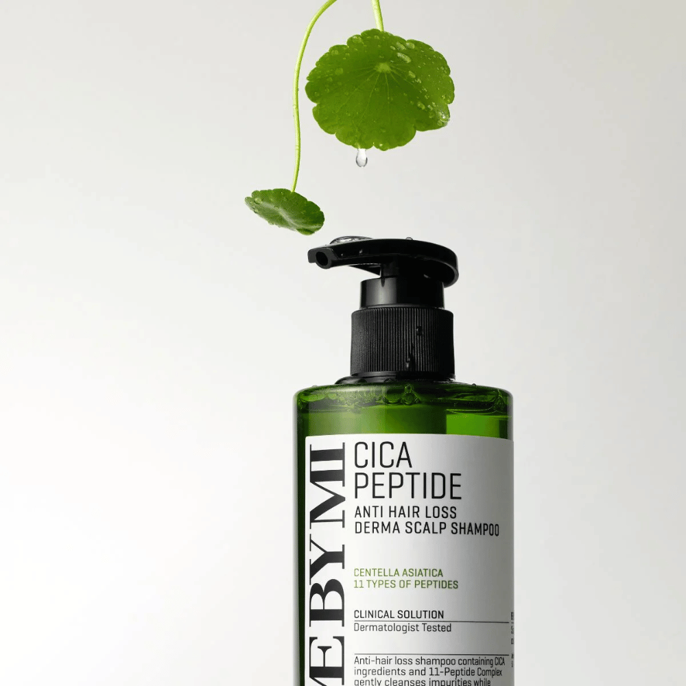 Fľaša s SOME BY MI Cica Peptide Anti Hair Loss Derma Scalp Shampoo v zelenej farbe s čiernou pumpičkou a bielou etiketou, obklopená listami centelly a kvapkou vody.