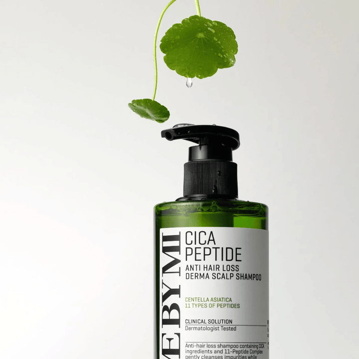 Fľaša s SOME BY MI Cica Peptide Anti Hair Loss Derma Scalp Shampoo v zelenej farbe s čiernou pumpičkou a bielou etiketou, obklopená listami centelly a kvapkou vody.