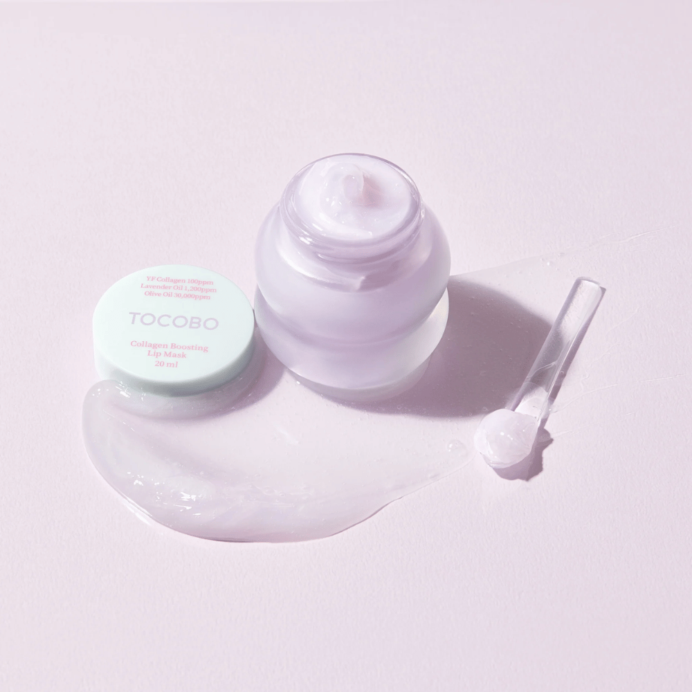 Otvorená nádoba TOCOBO Collagen Boosting Lip Mask so špachtľou a rozotretým fialovým krémom na svetlofialovom pozadí.