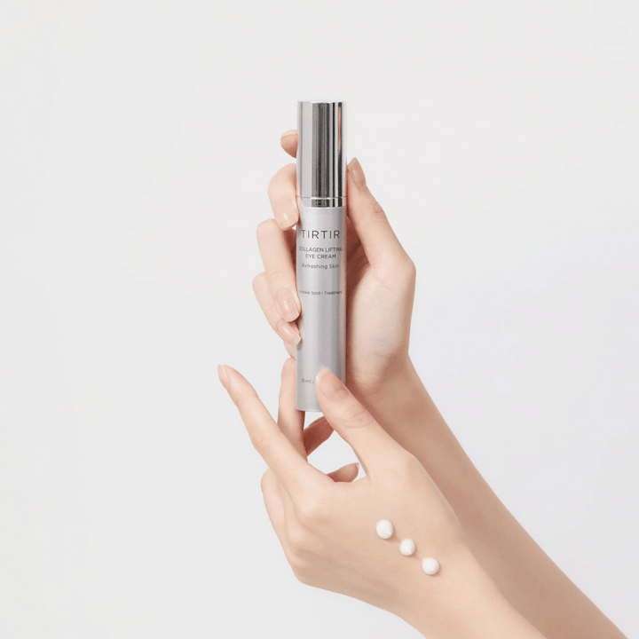 Ruky držiace tubu s TIRTIR Collagen Lifting Eye Cream, s vytlačeným produktom na chrbte ruky.