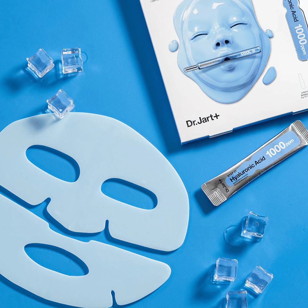 Dr.Jart+ Cryo Rubber Moisturizing Mask s dvojdielnou modrou gumovou maskou, kockami ľadu, ampulkou s kyselinou hyalurónovou a balením na modrom pozadí.