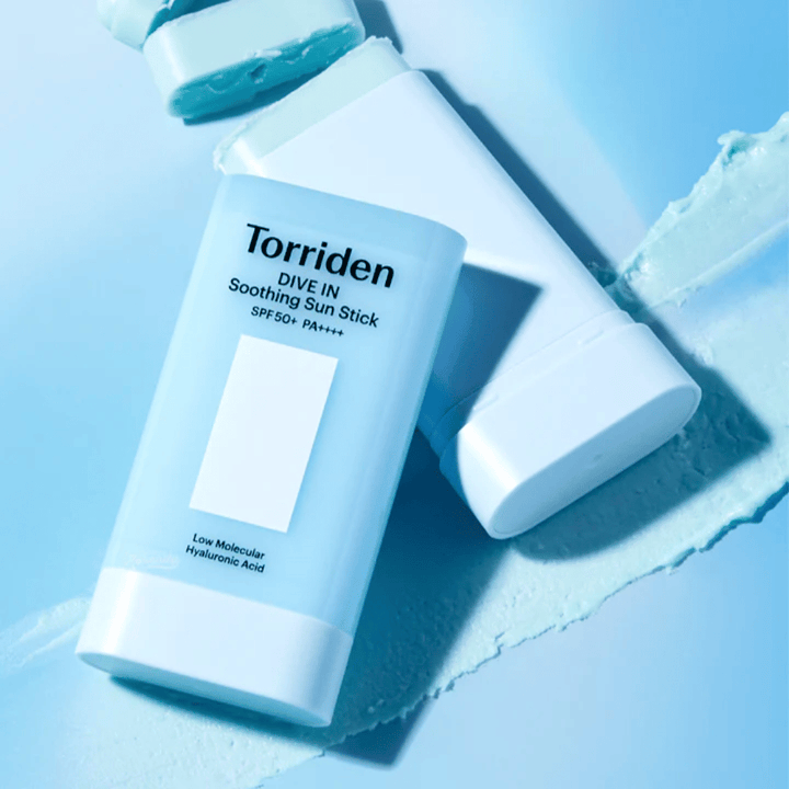 Torriden DIVE IN Soothing Sun Stick SPF50+ PA++++ spolu s rozotretou textúrou produktu, ktorá ilustruje hydratačnú a ľahkú aplikáciu.