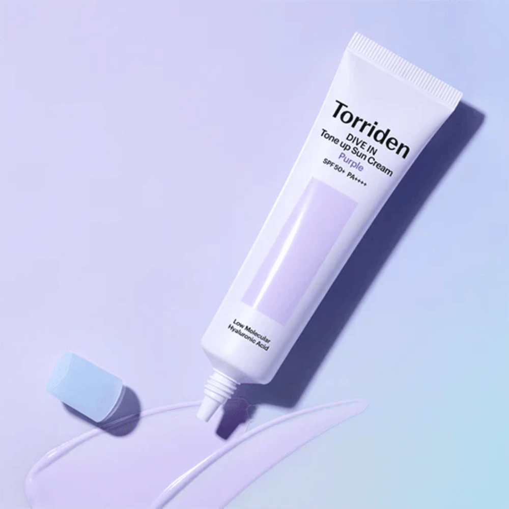 Otvorená tuba Torriden DIVE IN Tone Up Sun Cream Purple s fialovo tónovanou textúrou opaľovacieho krému, ktorá ukazuje farebne korigujúce zloženie produktu.