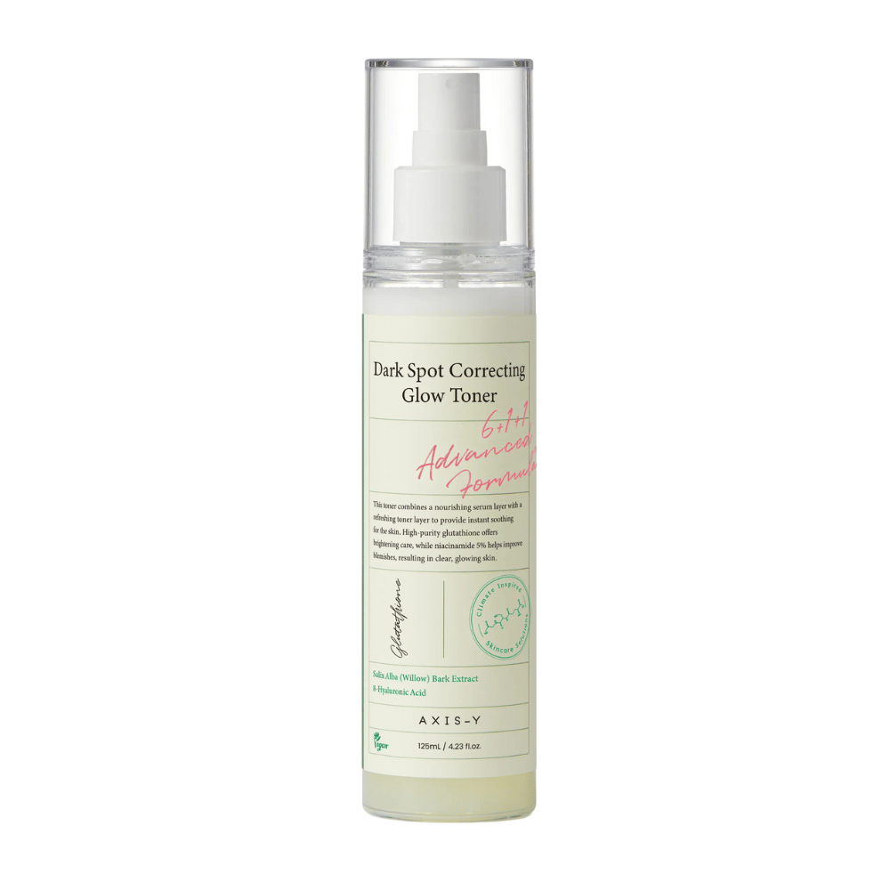 Obrázok fľaše produktu "AXIS-Y Dark Spot Correcting Glow Toner". Fľaša je priehľadná s bielou etiketou a textom v čiernej a zelenej farbe. Produkt je toner v spreji a fľaša obsahuje 125 ml (4,23 fl. oz). Etiketa uvádza kľúčové zložky ako Willow Bark Extract a Hyaluronic Acid.