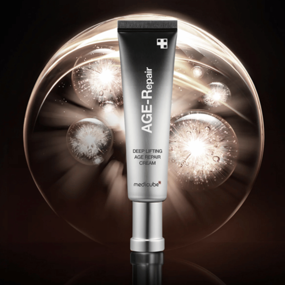 Medicube Deep Lifting Age Repair Cream v striebornej tube na pozadí so svetelnými efektmi, symbolizuje anti-aging a obnovu pokožky.