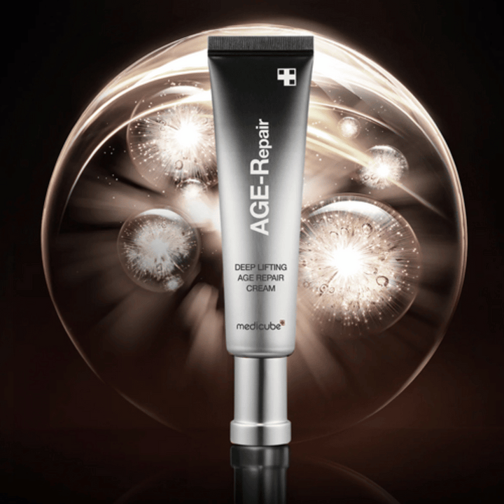 Medicube Deep Lifting Age Repair Cream v striebornej tube na pozadí so svetelnými efektmi, symbolizuje anti-aging a obnovu pokožky.