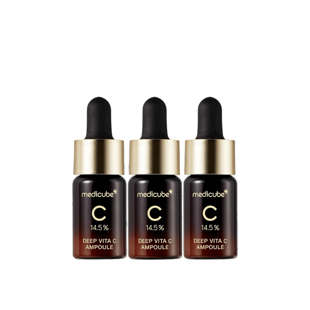 Tri fľaše Medicube Deep Vita C Ampoule, s 14,5 % vitamínu C, usporiadané v rade. Fľaše majú elegantný dizajn s tmavohnedým základom a zlatým uzáverom. Perfektné pre svetlejší tón pleti a rovnomernejšiu textúru pokožky.