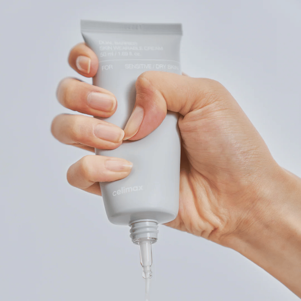 Ruka aplikujúca Celimax Dual Barrier Skin Wearable Cream, posilňujúci pleťový krém pre citlivú a suchú pokožku, ktorý poskytuje dlhodobú hydratáciu a chráni kožnú bariéru.