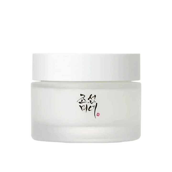 Obrázok zobrazuje nádobu "Beauty of Joseon Dynasty Cream". Balenie je z matného skla s jednoduchým bielym viečkom, elegantne zdobené tradičnou kórejskou kaligrafiou v čiernej farbe. Produkt je určený na poskytnutie výživnej starostlivosti o pleť inšpirovanej starými kórejskými kozmetickými rituálmi.