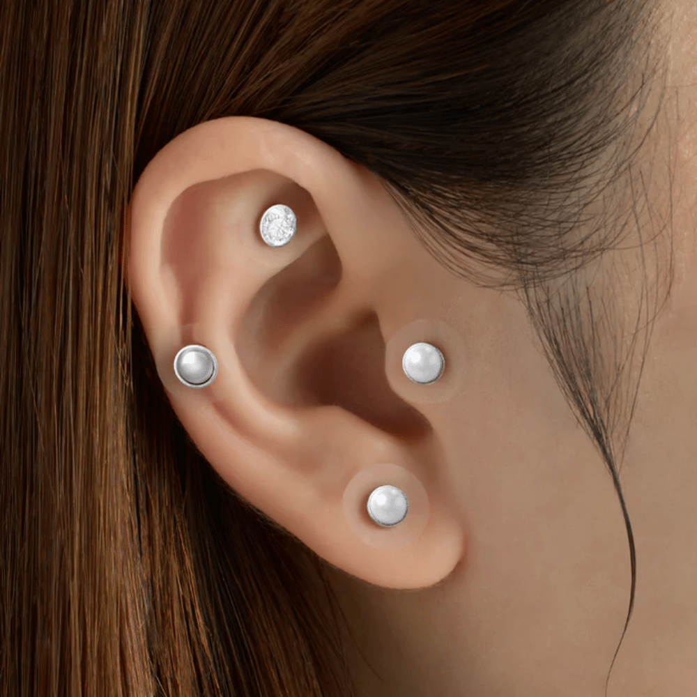 Detailný záber na ucho s viacerými RETURNITY Ear Therapy Acupressure Patch aplikovanými na rôzne oblasti ucha na akupresúru a elegantný vzhľad.