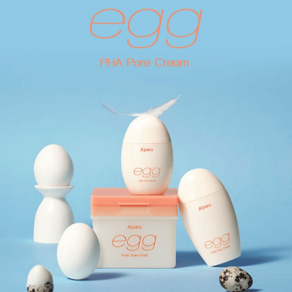 A'pieu Egg PHA Pore-séria – výrobky v tvare vajíčka ako sérum, krém a podložky, štýlovo usporiadané na modrom pozadí s vajíčkami a perím, ktoré symbolizujú jemnú starostlivosť o pleť.
