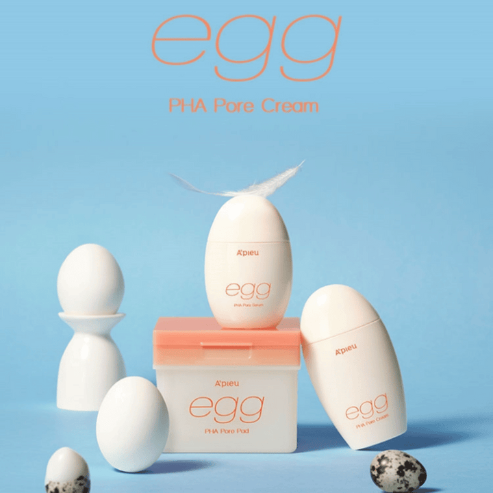 A'pieu Egg PHA Pore-séria – výrobky v tvare vajíčka ako sérum, krém a podložky, štýlovo usporiadané na modrom pozadí s vajíčkami a perím, ktoré symbolizujú jemnú starostlivosť o pleť.