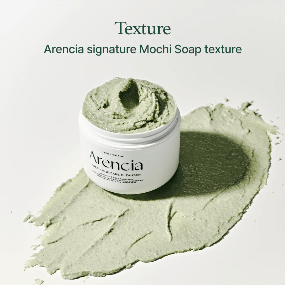 Arencia Fresh Rice Cake Cleanser v otvorenej nádobe s krémovou zelenou mochi podobnou textúrou rozprestretou okolo nádoby na bielom podklade.