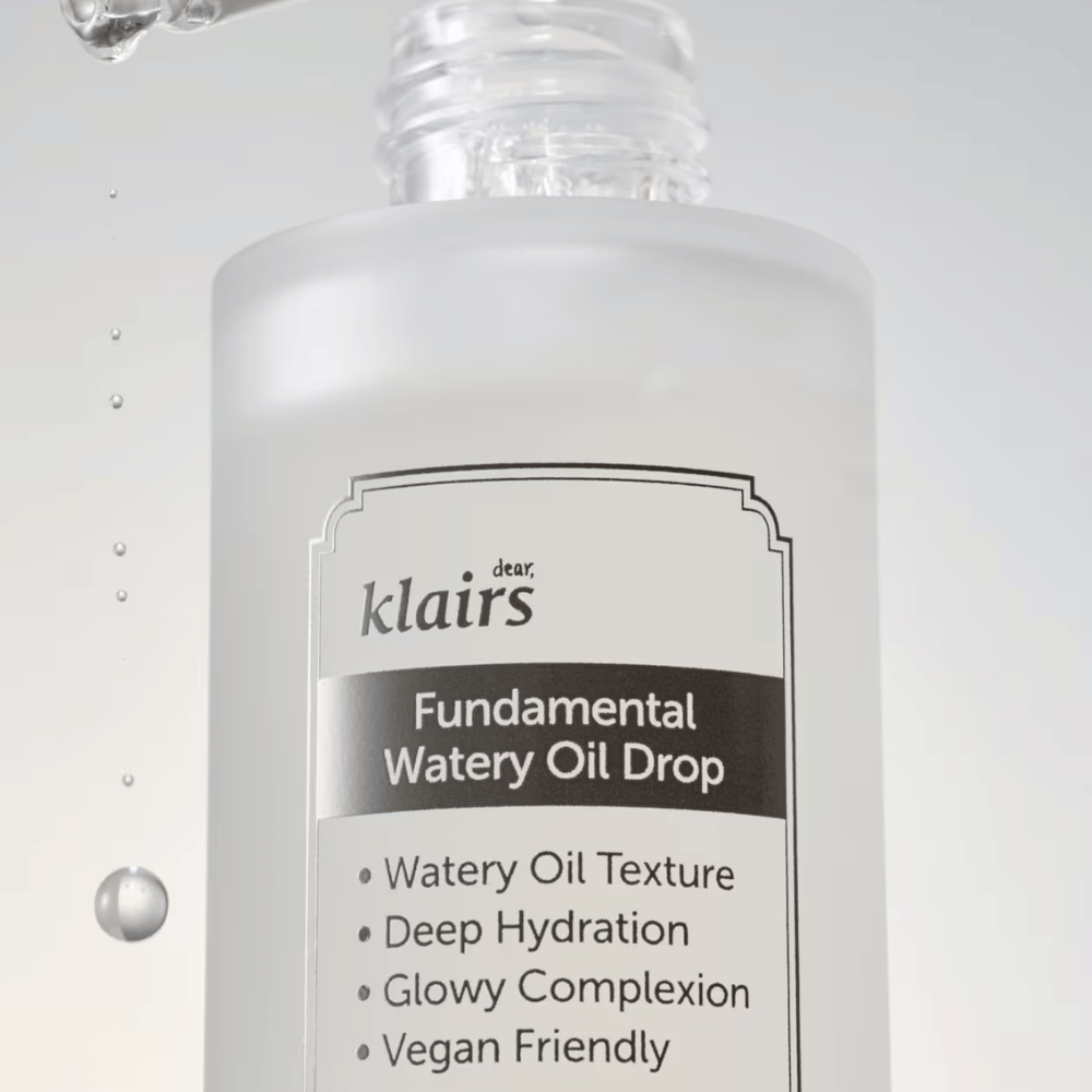 Detailný záber na fľašu Klairs Fundamental Watery Oil Drop, s textom, ktorý vyzdvihuje vlastnosti produktu ako "Watery Oil Texture", "Deep Hydration", "Glowy Complexion" a "Vegan Friendly".