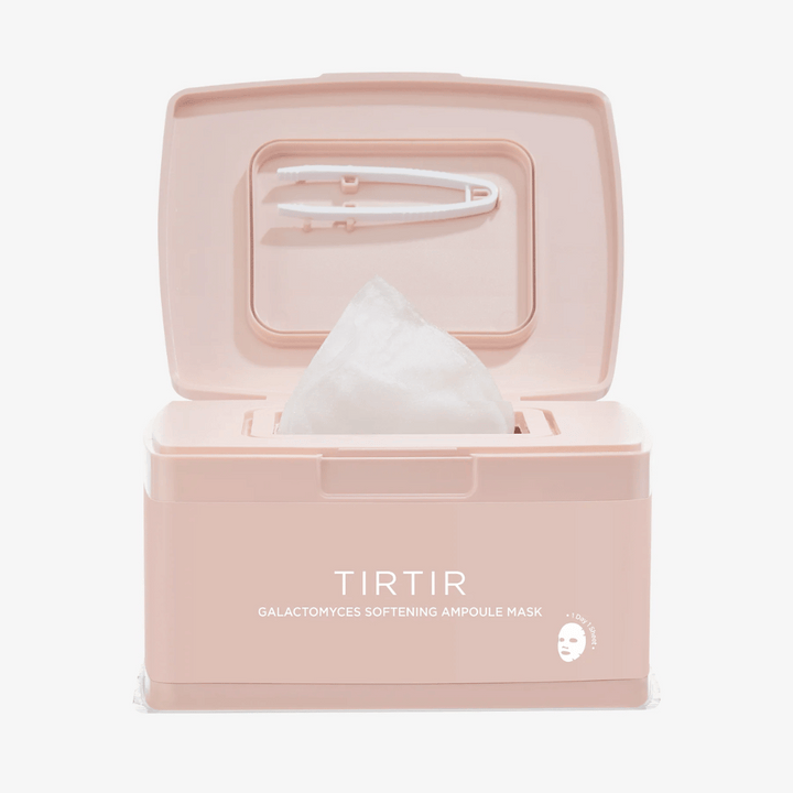 Ružové balenie s otvoreným vekom, ktoré ukazuje vyvýšenú pleťovú masku a priloženú pinzetu pripevnenú na vnútornej strane veka, označené textom "TIRTIR GALACTOMYCES SOFTENING AMPOULE MASK".