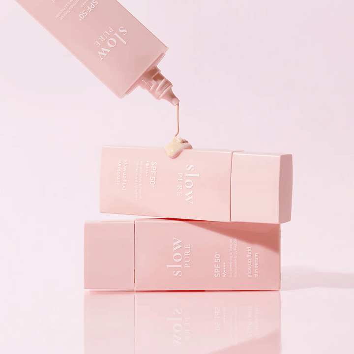 Slow Pure Glow Up Fluid Sun Serum s krémom vytlačeným z fľaše, ukazuje ľahkú a starostlivú konzistenciu.