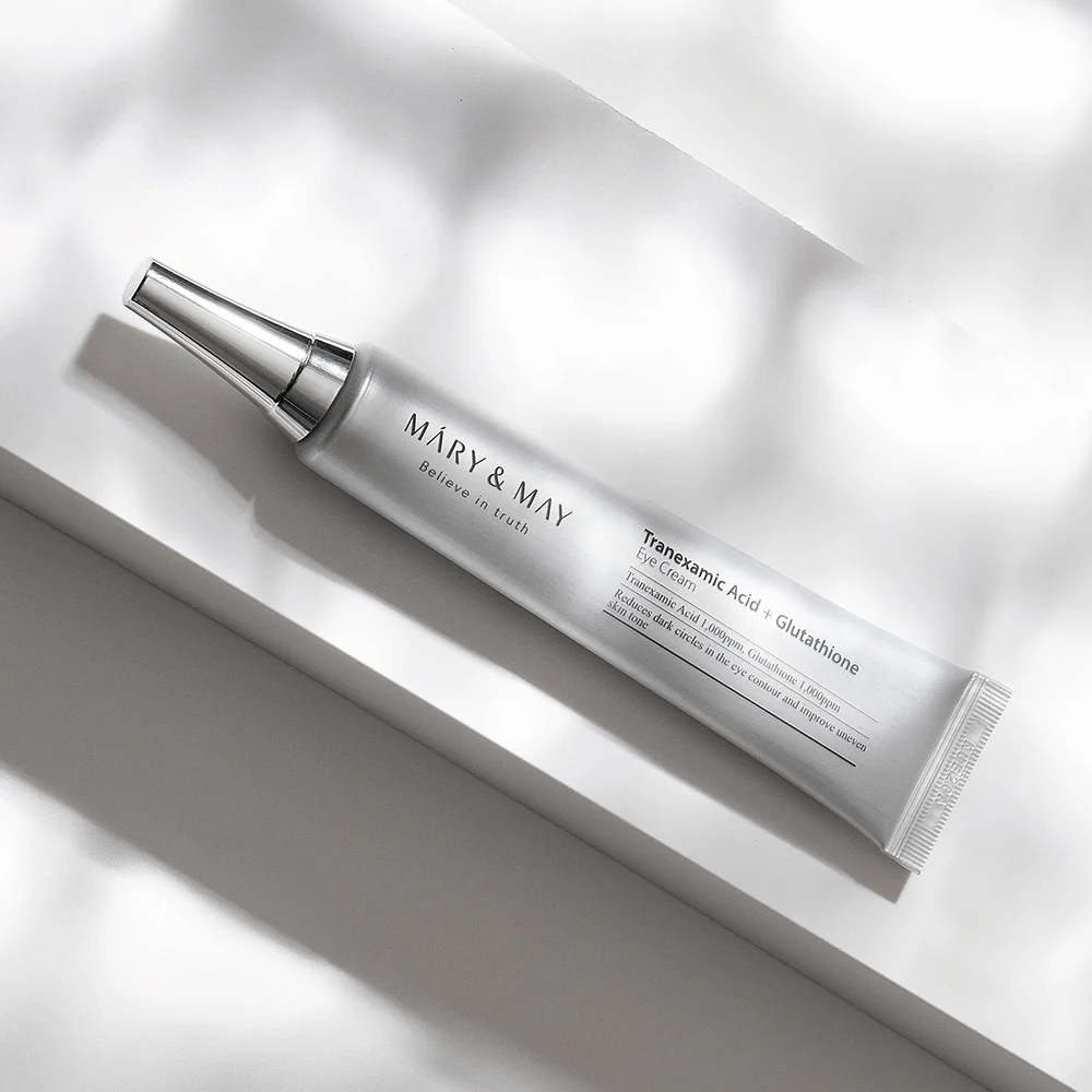 Detailný záber Mary&May Tranexamic Acid + Glutathione Eye Cream s kovovým aplikátorom, vyvinutý na zosvetlenie tmavých kruhov a vyrovnanie tónu pleti okolo očí.