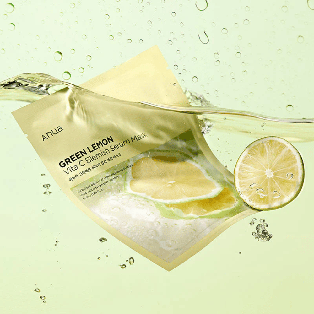 Živý obraz balenia Anua Green Lemon Vita C Blemish Serum Mask s priehľadnými kvapkami vody a plátkami zeleného citróna okolo. Balenie je čiastočne pokryté prúdom vody na svetlozelenom pozadí.