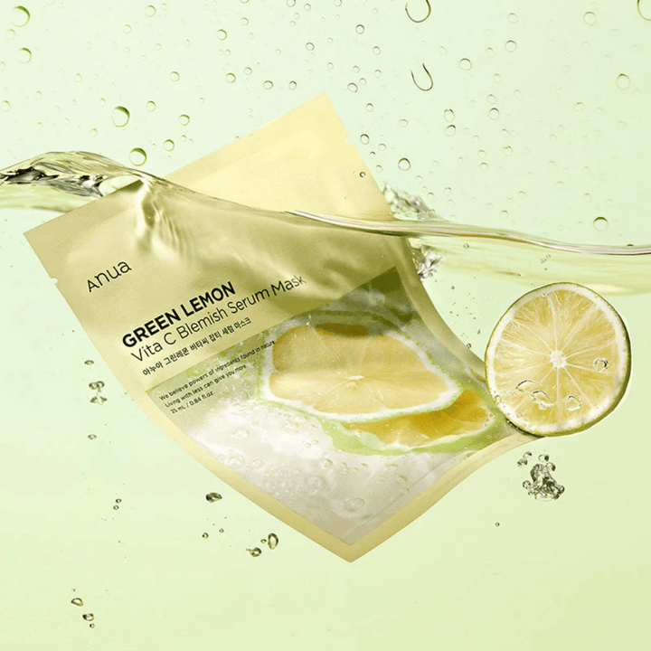 Živý obraz balenia Anua Green Lemon Vita C Blemish Serum Mask s priehľadnými kvapkami vody a plátkami zeleného citróna okolo. Balenie je čiastočne pokryté prúdom vody na svetlozelenom pozadí.